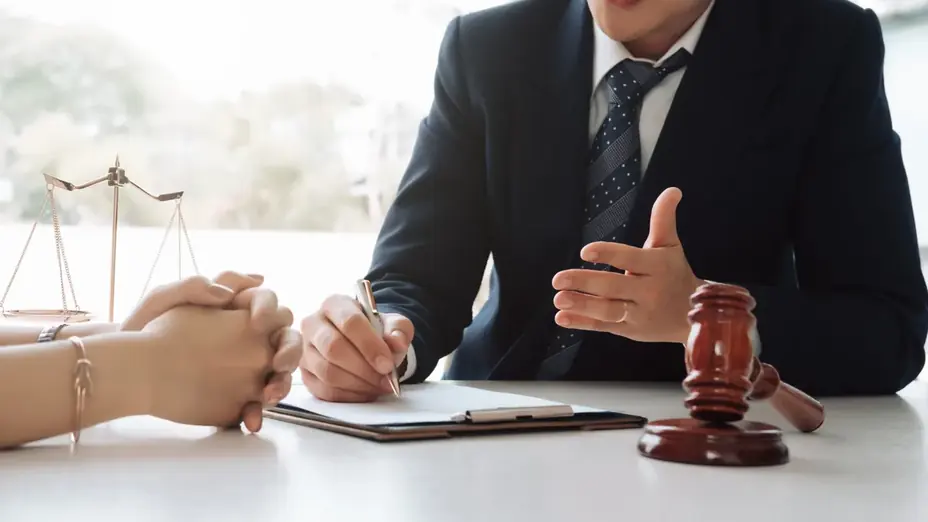 Atendimento jurídico em mesa com símbolos do direito